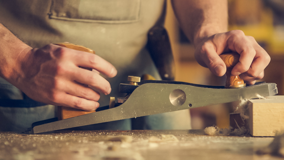Menuisier au travail sur un ouvrage bois massif